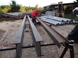 Au sol à droite, les poteaux assemblés qui attendent d'être fixés sur les fermes